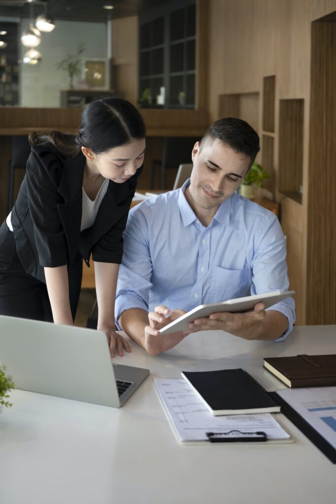 confident businessman holding digital tablet and shearing business plans with his colleague - Avalivel